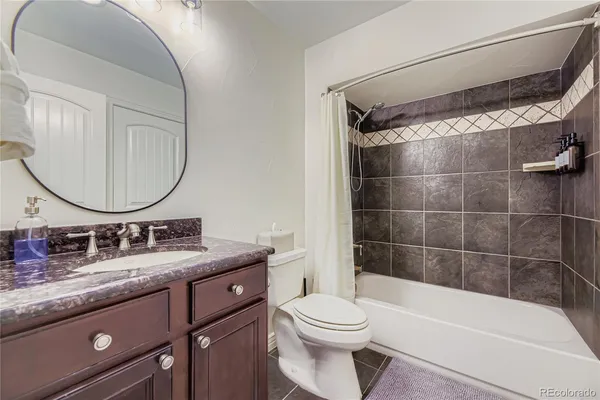 a bathroom with a granite countertop sink a toilet and a mirror