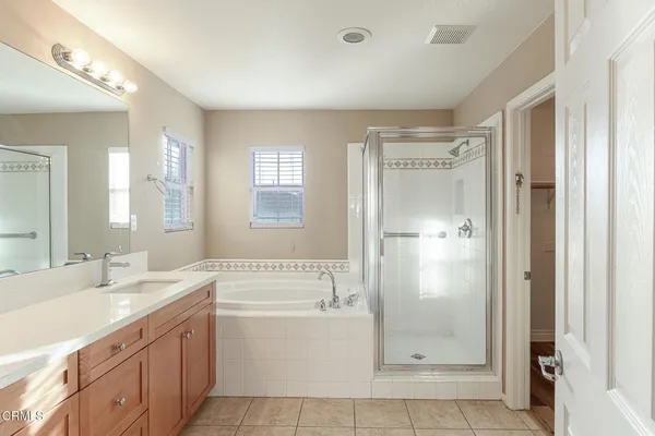 a bathroom with a tub sink shower and mirror