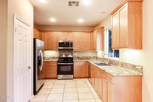 a kitchen with stainless steel appliances granite countertop a refrigerator and a stove top oven