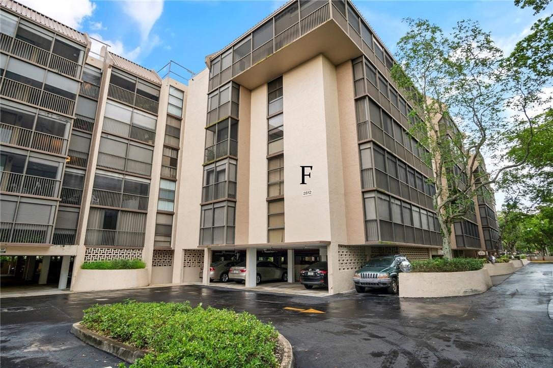 2810 North 46th Avenue, Unit 462 Hollywood, FL 33021 - Photo 29 of 31 a front view of a building with garden and trees