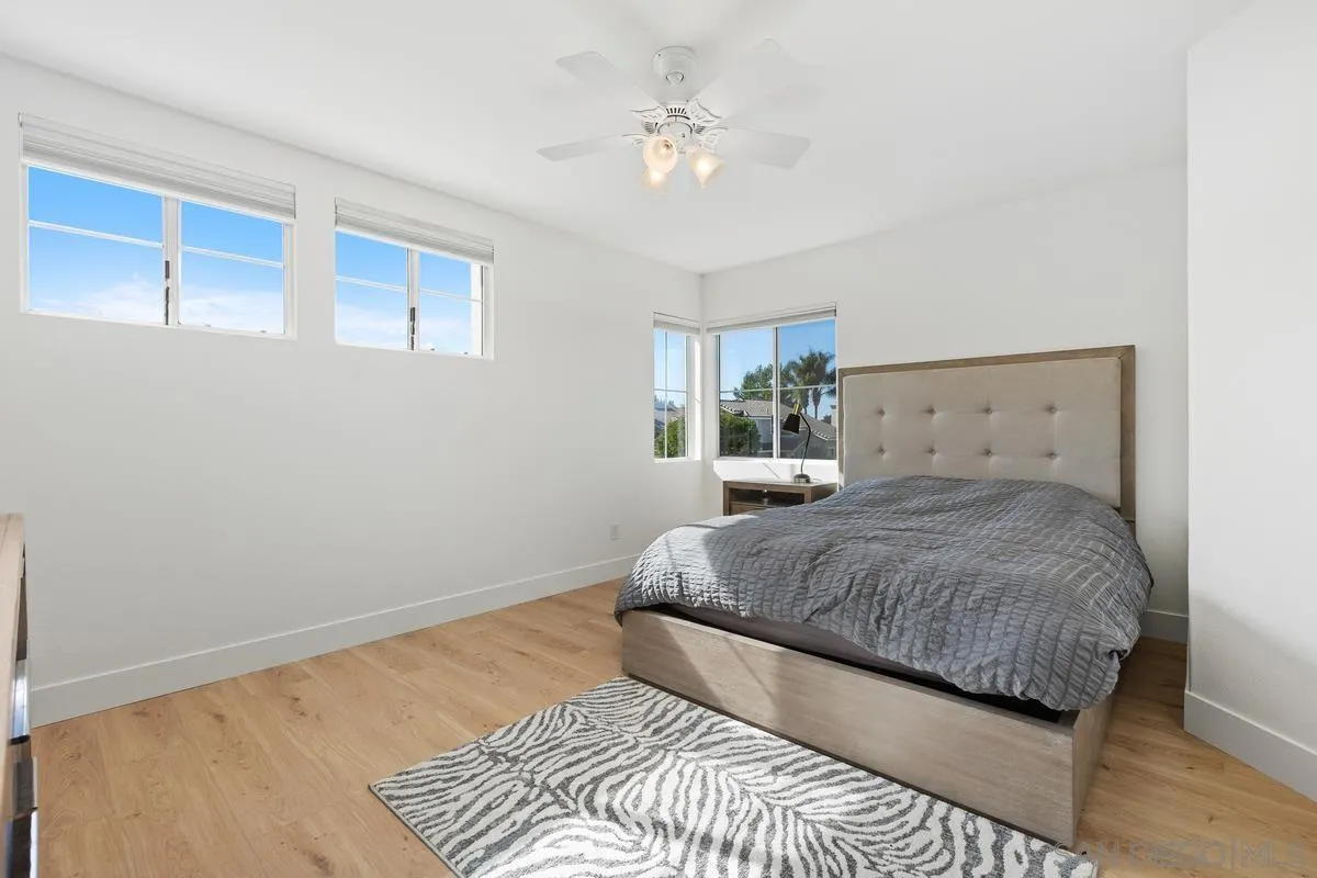 4802 Baroque Terrace Oceanside, CA 92057 - Photo 38 of 51 a bedroom with a large bed chandelier and a window