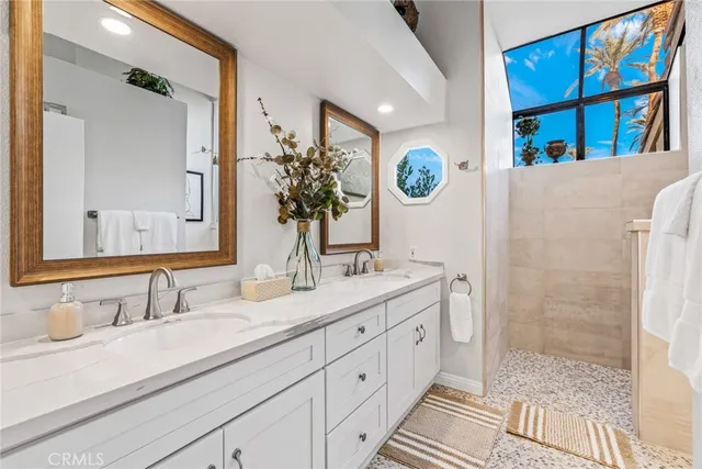 a bathroom with a granite countertop sink mirror and a shower