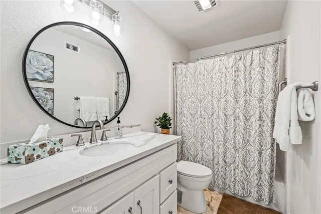 a bathroom with a sink mirror and toilet