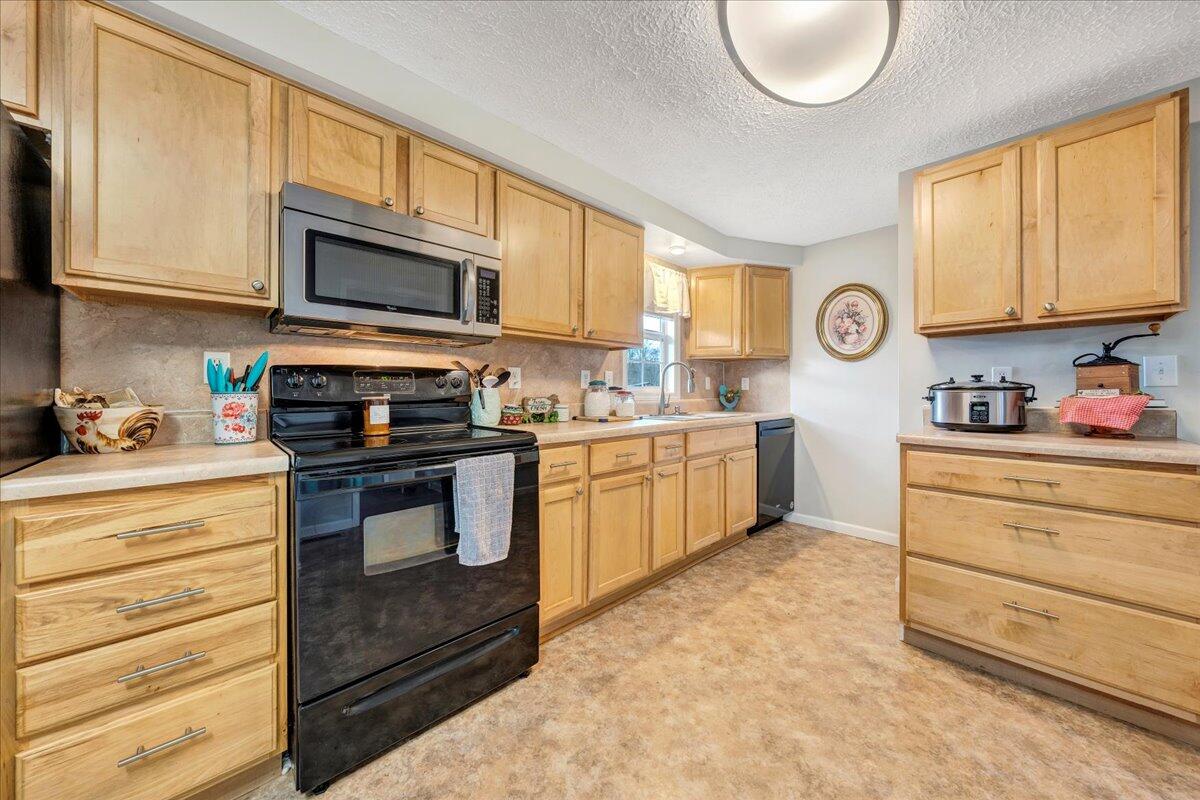 2152 Egg Farm Road Patrick Springs, VA 24133 - Photo 8 of 32 a kitchen with stainless steel appliances granite countertop a stove a sink and a microwave