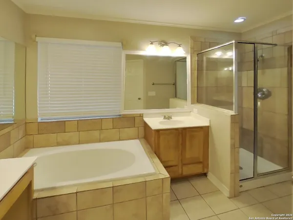 a bathroom with a tub a sink and glass door