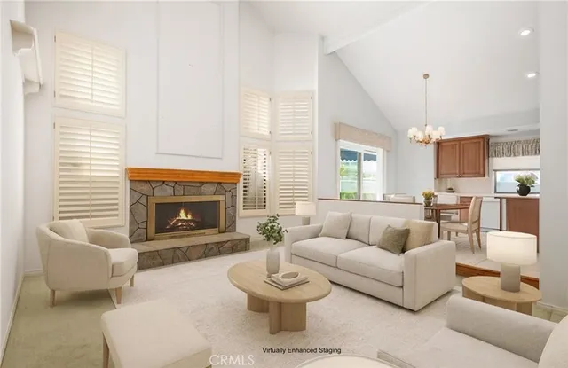 a living room with furniture a fireplace and a large window