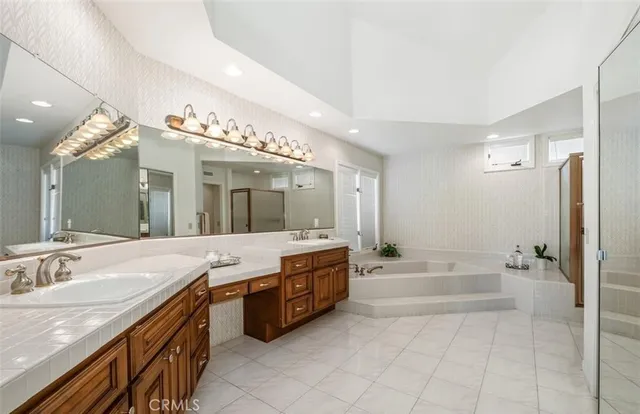 a spacious bathroom with a granite countertop sink mirror and bathtub