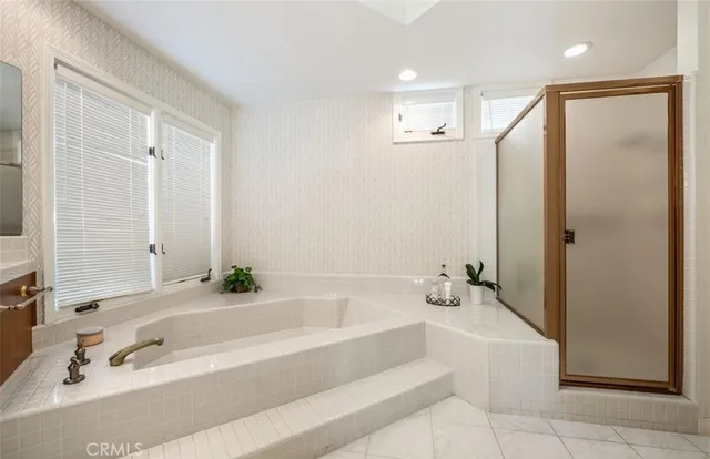 a bathroom with a tub a sink and a large mirror