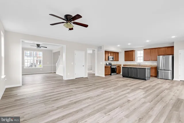 a view of a kitchen with a stove wooden cabinets and window