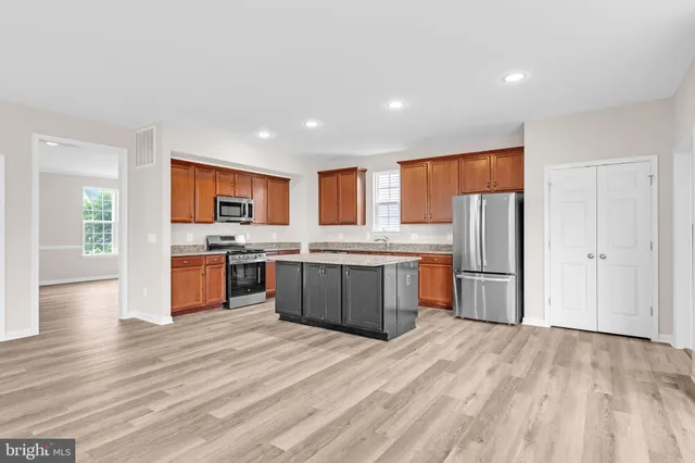 a kitchen with stainless steel appliances a refrigerator and a stove top oven