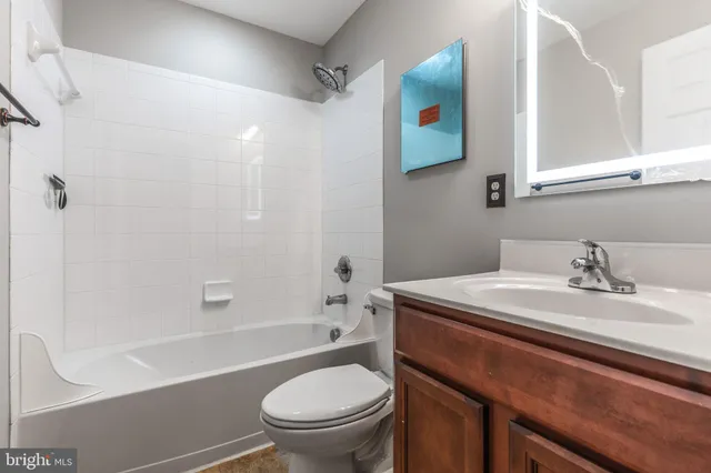 a bathroom with a sink toilet vanity and shower