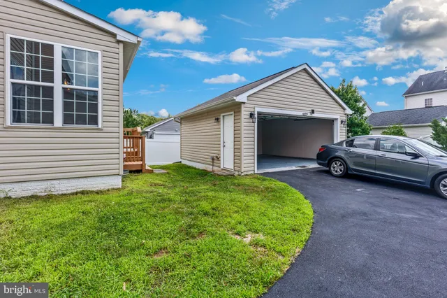 a backyard of a house with barbeque oven and fence