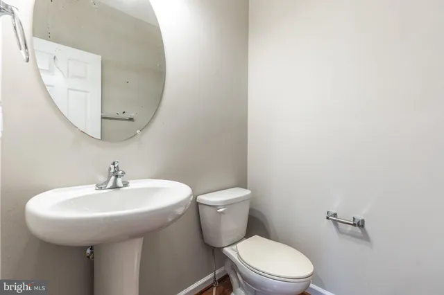 a bathroom with a toilet a sink and a mirror