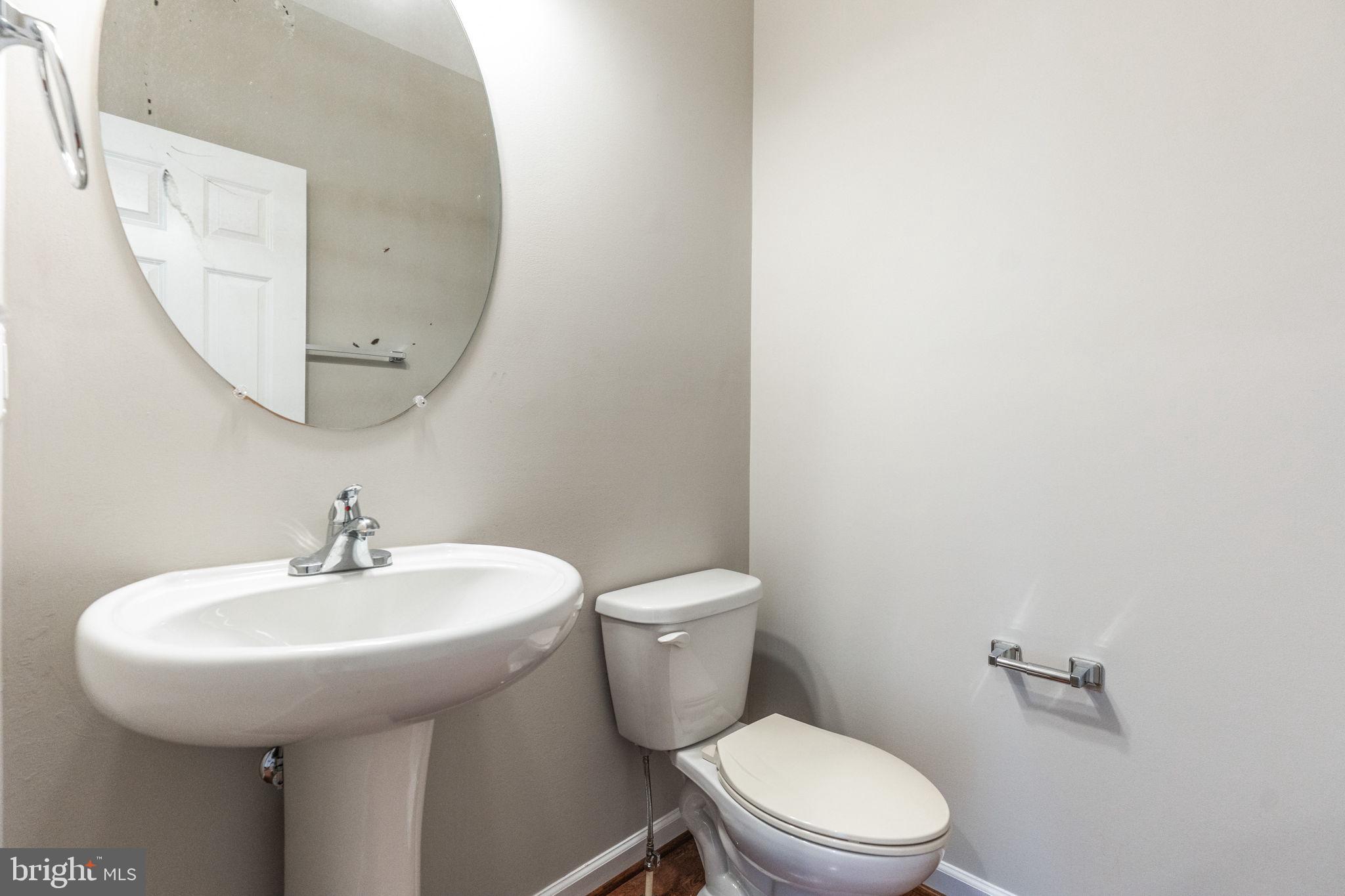 12021 Spring Beauty Road Bristow, VA 20136 - Photo 5 of 43 a bathroom with a toilet a sink and a mirror