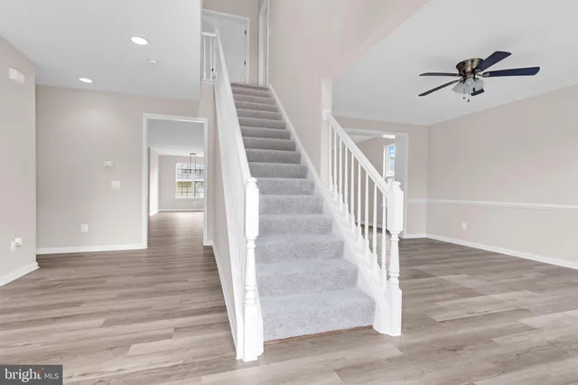 a view of a hallway view with wooden floor and staircase
