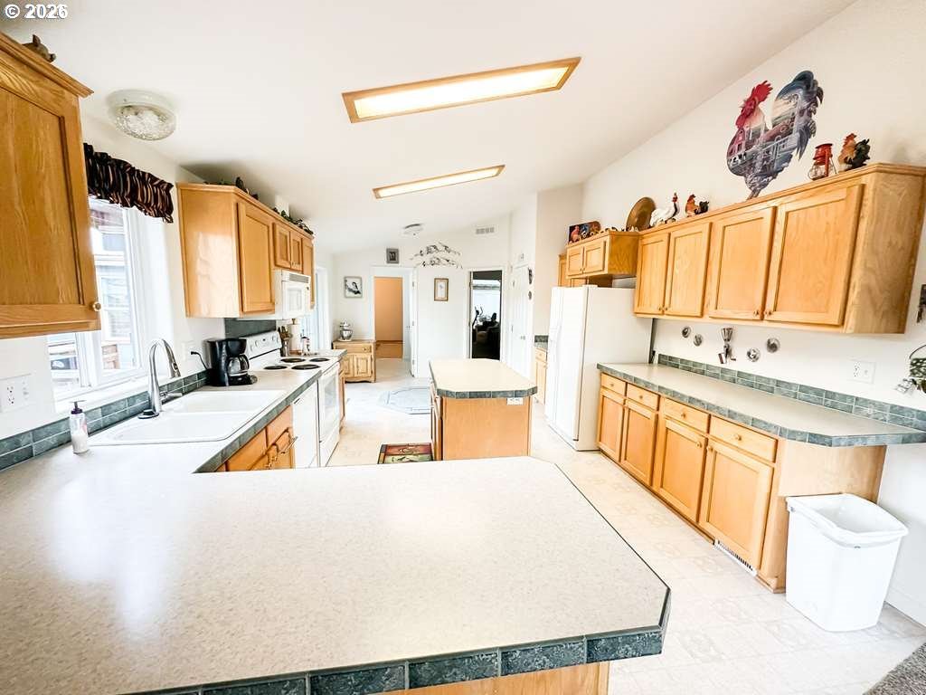 46198 Slaughterhouse Road Halfway, OR 97834 - Photo 4 of 40 a large white kitchen with stainless steel appliances a stove a sink a refrigerator and a white cabinets next to a window