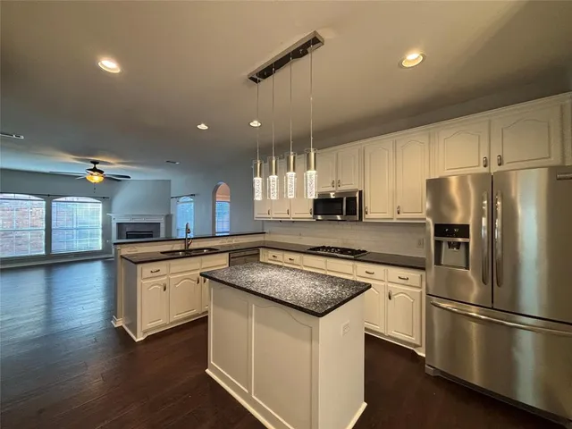 a kitchen with granite countertop a sink appliances cabinets and a counter top space