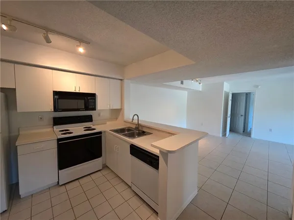 a kitchen with granite countertop a sink and a stove top oven