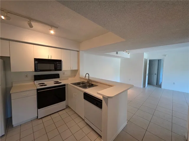 a kitchen with granite countertop a sink and a stove top oven