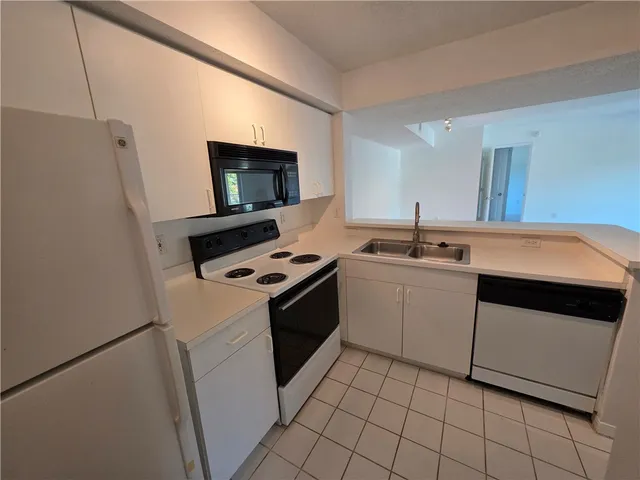a kitchen with a sink cabinets and appliances