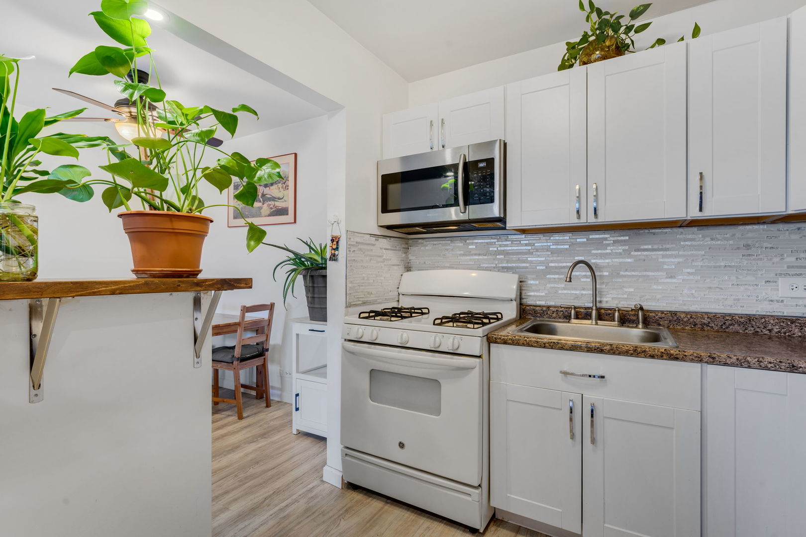 9820 South Pulaski Road, Unit 315 Oak Lawn, IL 60453 - Photo 4 of 20 a kitchen with stainless steel appliances white cabinets a stove a sink and a potted plant