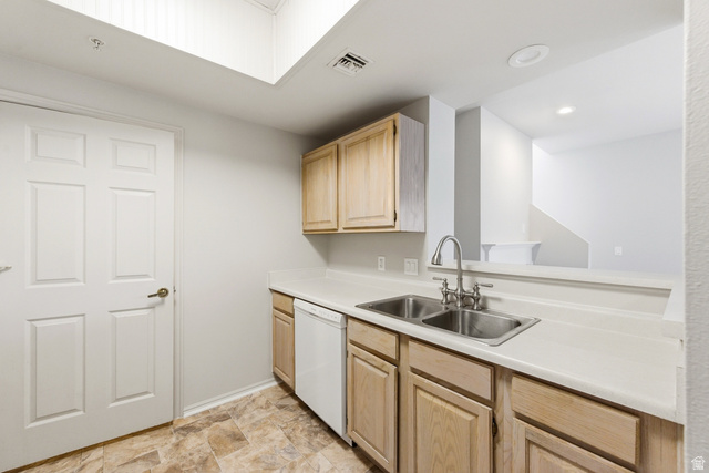 900 Bitner Road, Unit P20 Park City, UT 84098 - Photo 13 of 42 Kitchen area featuring light wood-finish cabinetry, a double basin stainless steel sink with a gooseneck faucet, a white dishwasher, light-toned countertops, and patterned floor tiling