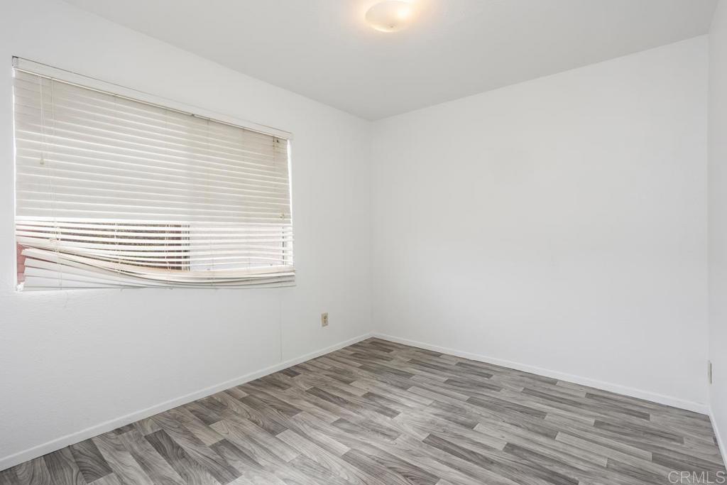 4537 Beverly Glen Drive Oceanside, CA 92056 - Photo 26 of 30 an empty room with wooden floor and a window