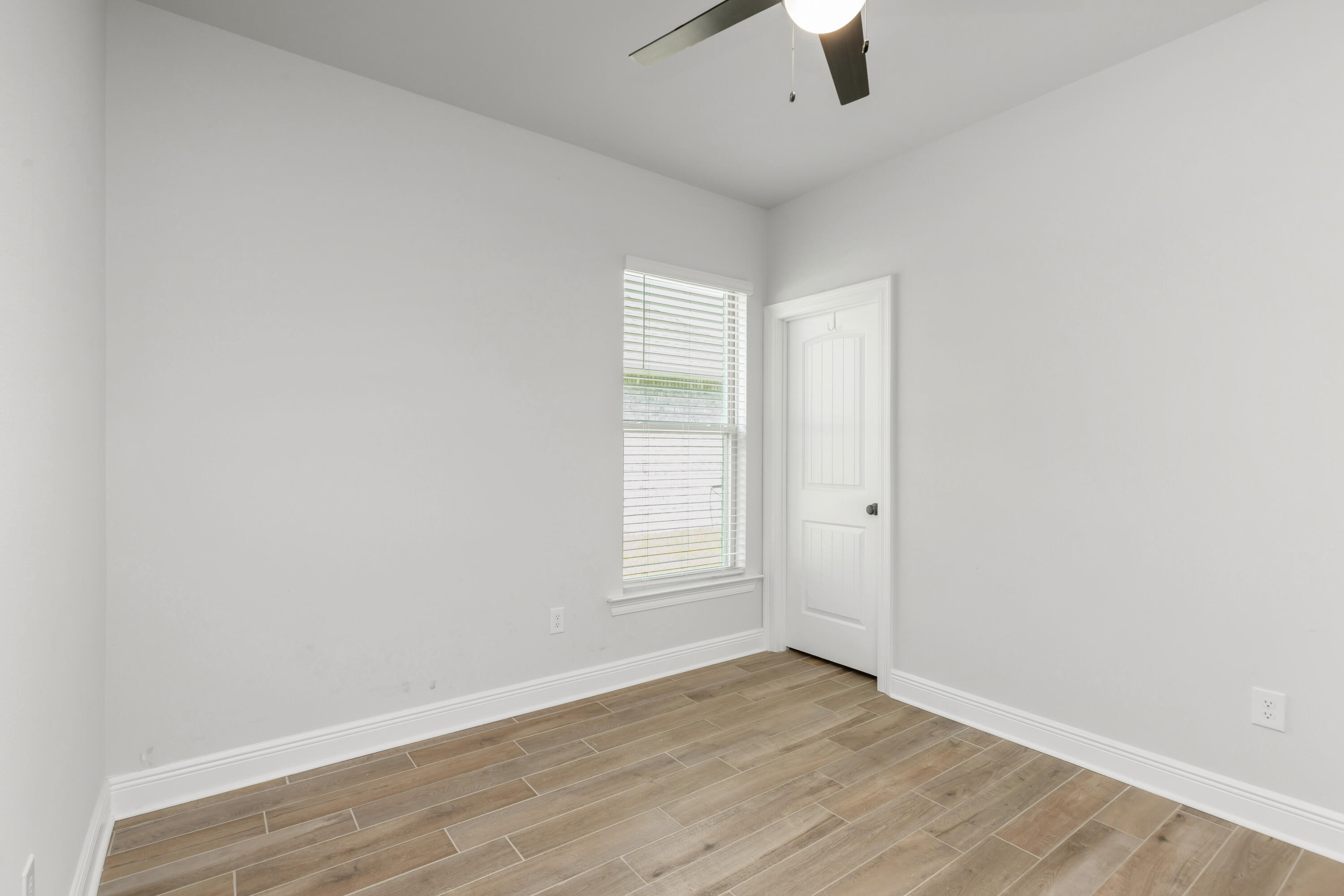 27 Cozy Cove Freeport, FL 32439 - Photo 26 of 80 an empty room with wooden floor chandelier fan and windows