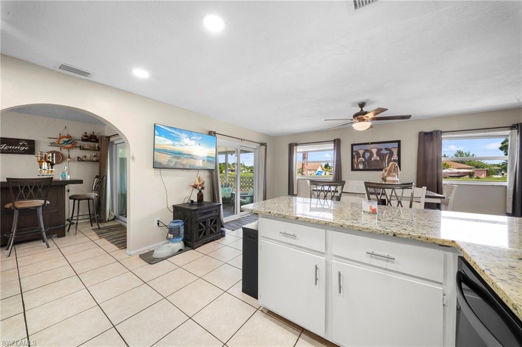 7289 Barragan Road Fort Myers, FL 33967 - Photo 6 of 18 Kitchen island featuring a light granite countertop and white cabinetry with brushed nickel hardware