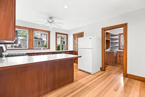 a large kitchen with stainless steel appliances a large counter top and a wooden floor