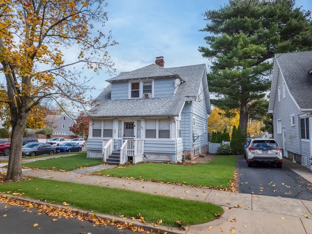 a front view of a house with a yard and potted plants
