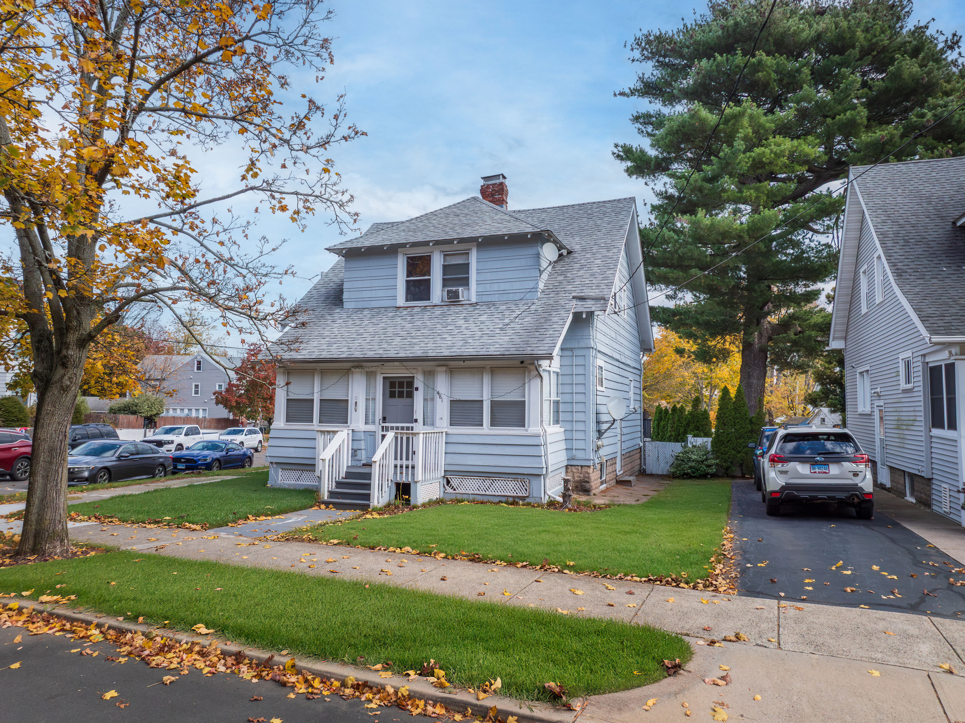 a front view of a house with a yard and potted plants
