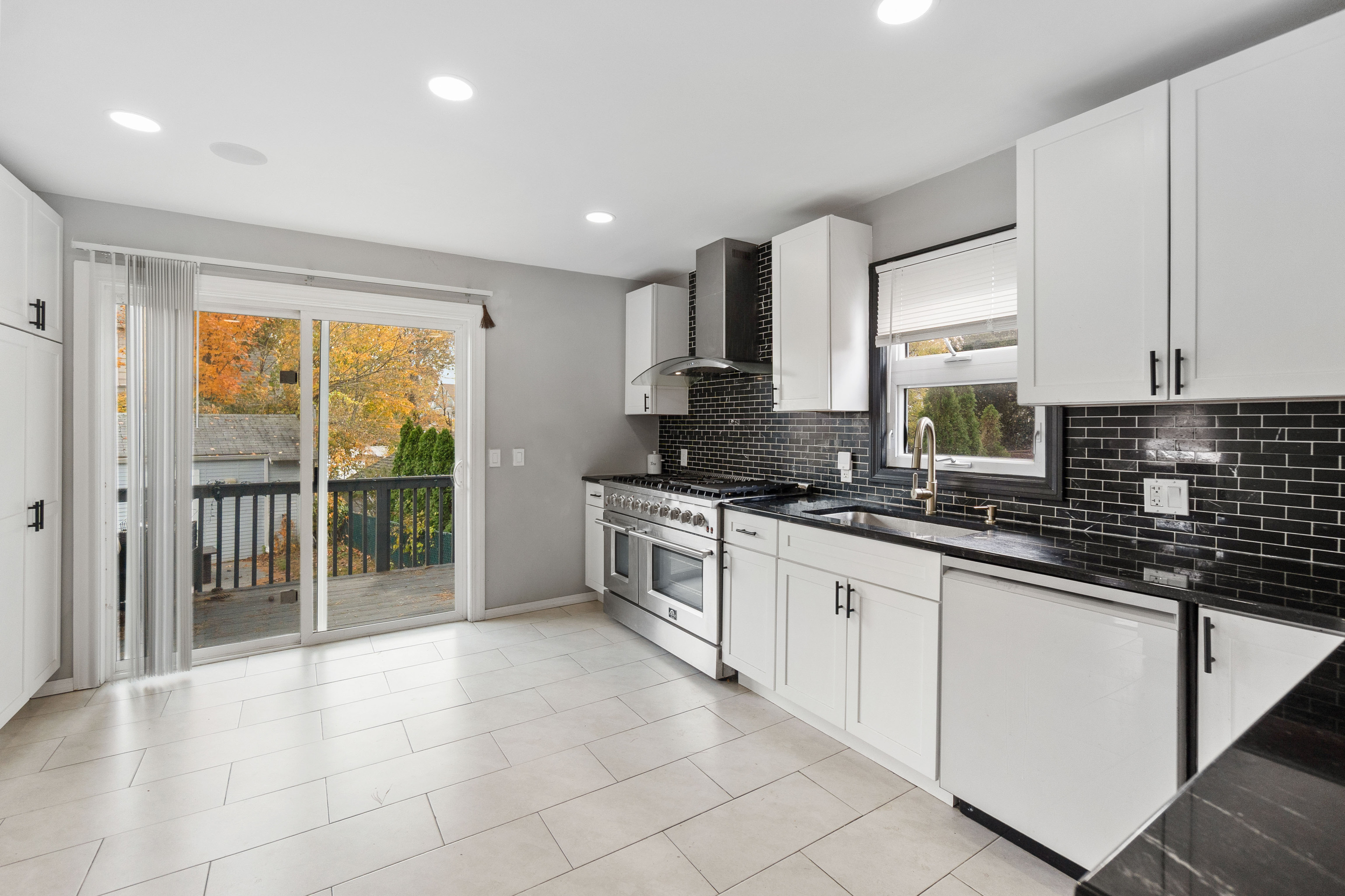 481 Savin Avenue West Haven, CT 06516 - Photo 3 of 21 a large kitchen with granite countertop a sink and white cabinets