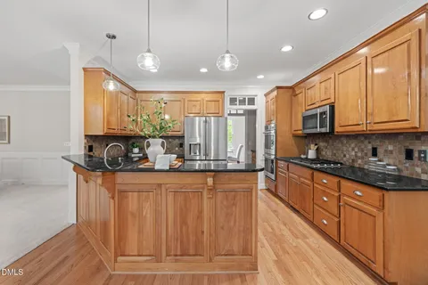 a kitchen with stainless steel appliances granite countertop wooden cabinets a stove top oven a sink and dishwasher