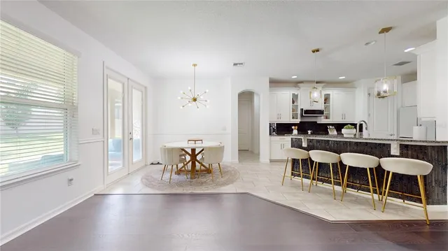 a living room with furniture kitchen view and a large window