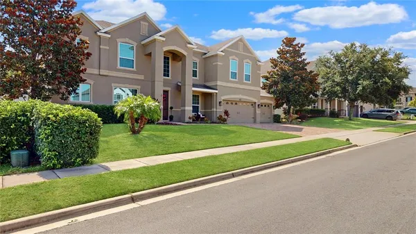 a front view of a house with a yard and trees