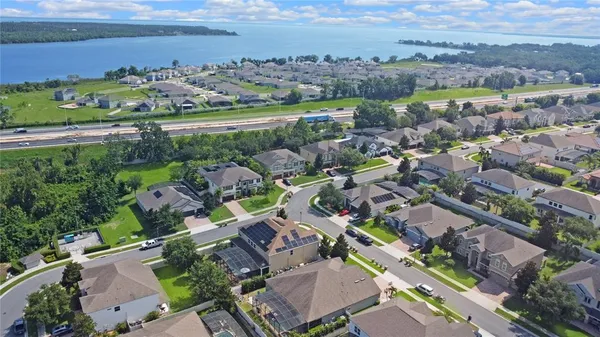 an aerial view of a city with lots of residential buildings ocean and mountain view in back