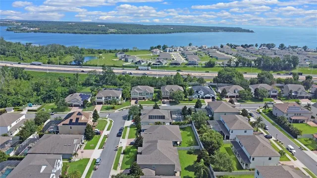 an aerial view of a city with lots of residential buildings ocean and mountain view in back