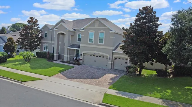 a front view of a house with a garden and trees