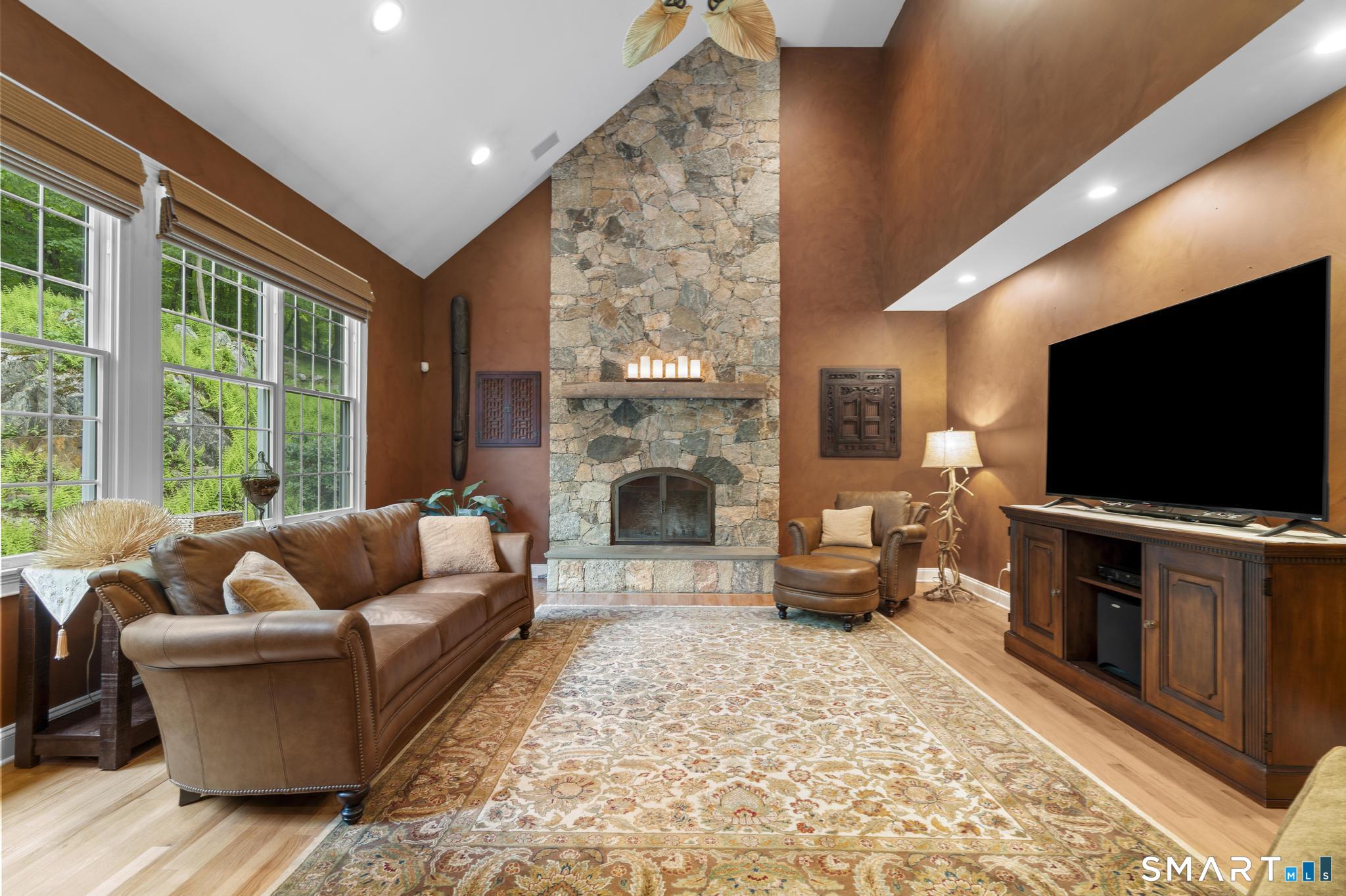 12 Logans Way Danbury, CT 06811 - Photo 8 of 40 a living room with furniture a flat screen tv and a fireplace