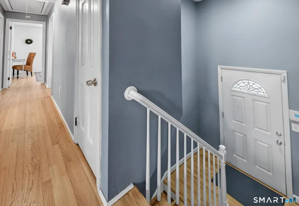 a view of a hallway with wooden floor and staircase