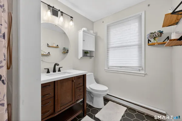 a bathroom with a sink a toilet and a mirror