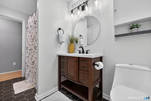 a bathroom with a sink a toilet and a mirror