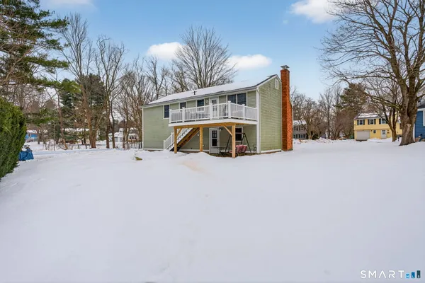 a view of a house with a yard covered in snow
