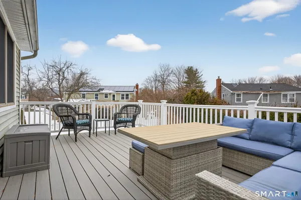 a balcony with wooden floor table and chairs