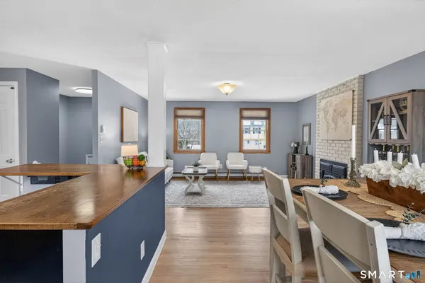 a living room with fireplace furniture flat screen tv and two windows