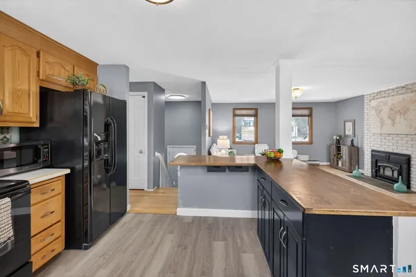 a kitchen with granite countertop a refrigerator a stove top oven and a sink