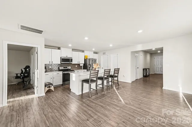 a view of kitchen dining table wooden floor and a view of kitchen