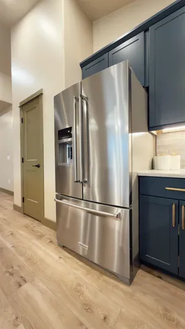 a metallic refrigerator freezer sitting in a kitchen