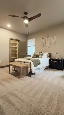 a spacious bedroom with a bed and a chandelier